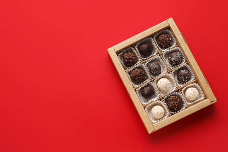 Box with sweet chocolate candies on color backgroundの写真素材