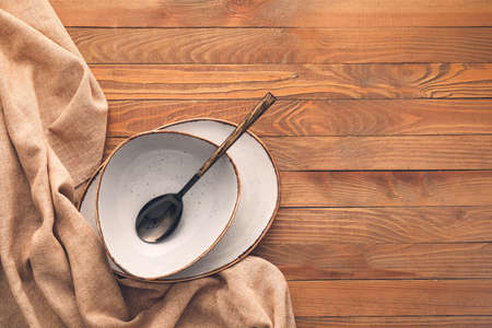 Clean spoon with plates on wooden backgroundの写真素材