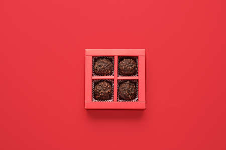 Box with sweet chocolate candies on color background