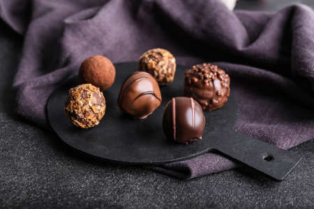 Board with sweet chocolate candies on dark backgroundの写真素材