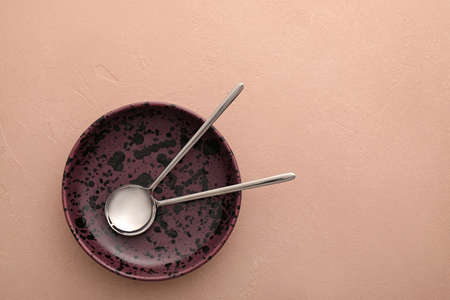 Clean spoons with plate on color backgroundの写真素材