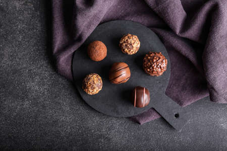 Board with sweet chocolate candies on dark backgroundの写真素材