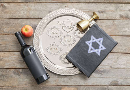 Passover Seder plate with wine and Torah on wooden backgroundの写真素材