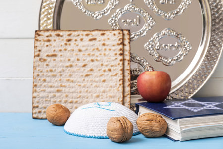 Passover Seder plate with Jewish cap, matzo and Torah on table