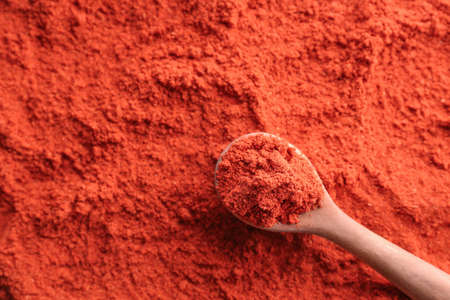 Spoon and red chili powder as background
