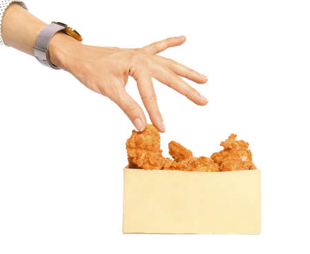 Woman taking tasty deep fried chicken wing from paper box on white backgroundの写真素材