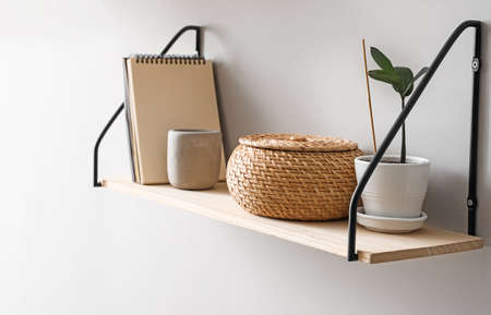 Modern shelf with decor hanging on light wallの写真素材