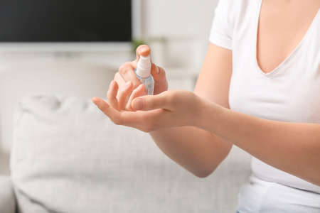 Young woman using sanitizer at homeの写真素材