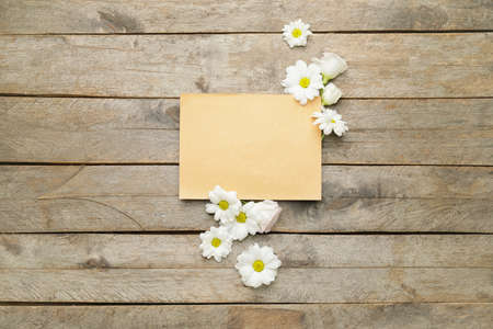 Blank card and beautiful flowers on wooden backgroundの写真素材