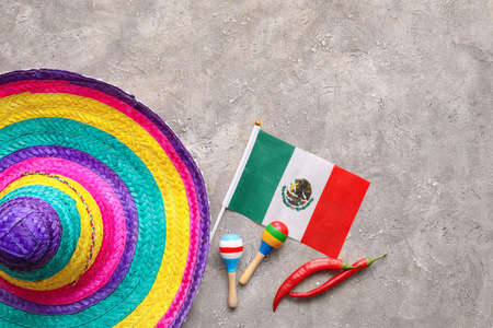 Mexican flag, sombrero hat, maracas and chili peppers on gray backgroundの写真素材