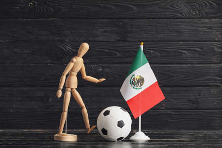 Wooden mannequin, Mexican flag and soccer ball on dark wooden backgroundの写真素材