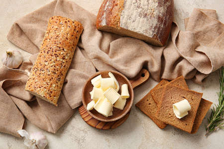 Fresh bread and butter on light background