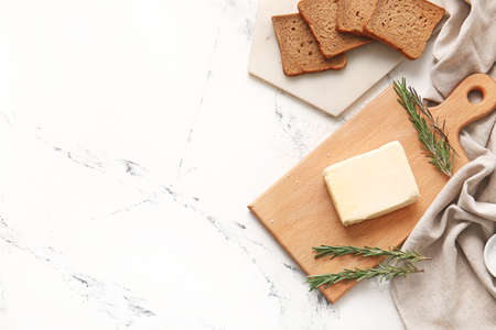 Fresh butter and rosemary on light background