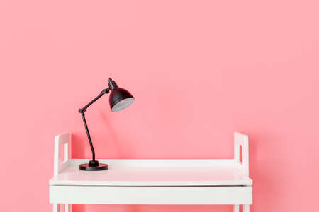 Modern table with lamp on color backgroundの写真素材