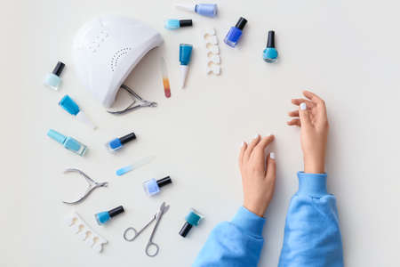 Female hands and tools for manicure on white backgroundの写真素材
