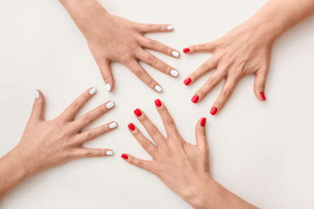 Many female hands with beautiful manicure on white background, closeup