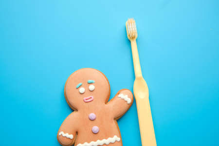Tooth brush with Christmas cookie on color backgroundの写真素材
