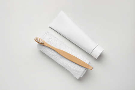 Tooth brush with paste and towel on white background