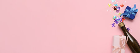 Bottle of champagne with Christmas gifts and confetti on pink background with space for textの写真素材