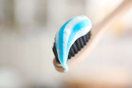 Tooth brush with paste on blurred background, closeup
