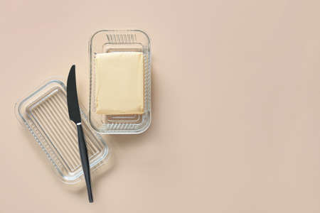 Box with fresh butter on light background