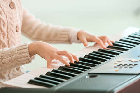 Little girl playing synthesizer at home, closeupの写真素材