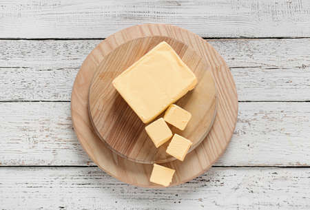 Chopping boards with fresh butter on wooden background
