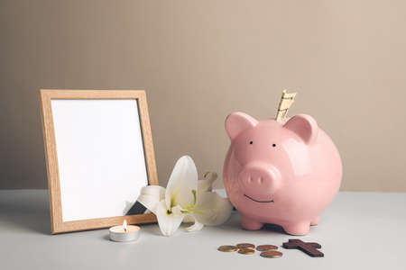 Piggy bank with photo frame and lily flower on light backgroundの写真素材