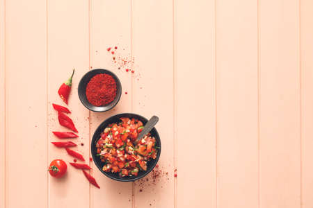 Bowl of tasty salsa sauce on color wooden backgroundの写真素材