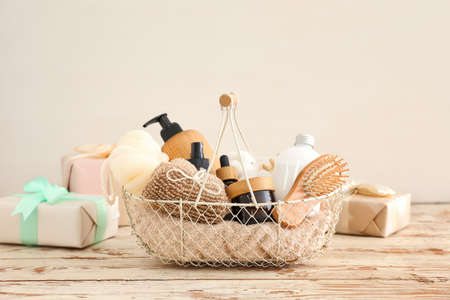 Gift basket with cosmetic products on light wooden backgroundの写真素材