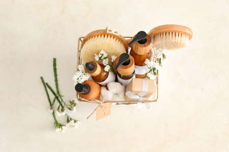 Gift basket with cosmetic products on light background