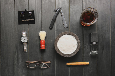Stylish male accessories and glass of whiskey on dark wooden backgroundの写真素材