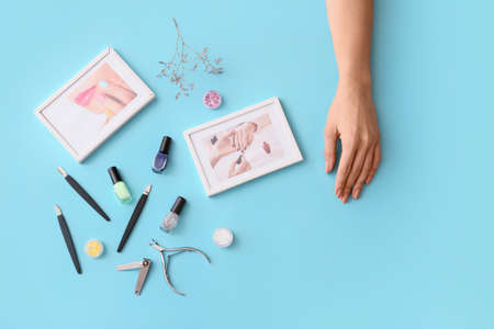Female hand, professional tools for manicure, nail polishes and pictures on color backgroundの写真素材