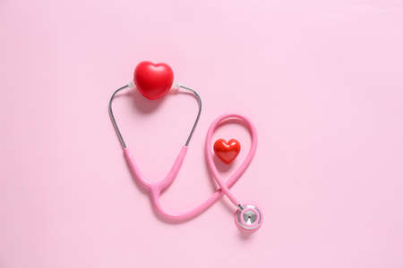 Modern stethoscope and hearts on color backgroundの写真素材