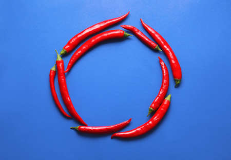 Frame made of hot chili peppers on color backgroundの写真素材