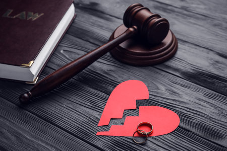Judge's gavel with broken heart and rings on dark wooden backgroundの写真素材