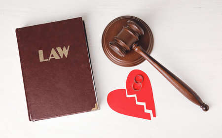 Judge's gavel with law book and broken heart on light backgroundの写真素材