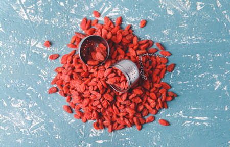 Infuser with dried goji berries on color backgroundの写真素材
