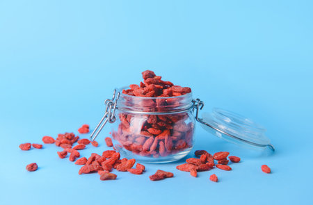 Jar with dried goji berries on color backgroundの写真素材