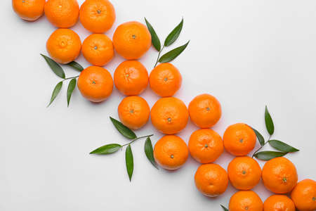 Composition with sweet tangerines and leaves on white background
