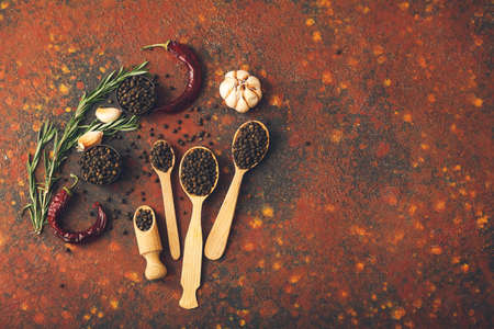 Spoons with peppercorns on grunge backgroundの写真素材