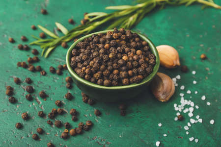 Bowl with peppercorns on color backgroundの写真素材