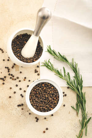 Bowl and mortar with peppercorns on light backgroundの写真素材