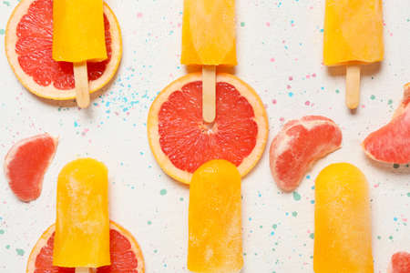 Tasty ice-cream and grapefruits on light backgroundの写真素材