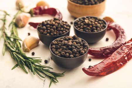 Bowls with peppercorns on light backgroundの写真素材