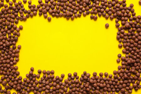 Frame made of chocolate corn balls on color backgroundの写真素材