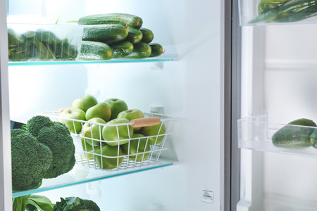 Open refrigerator full of green vegetablesの写真素材