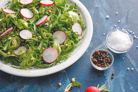 Plate of tasty salad with fresh vegetables on color background