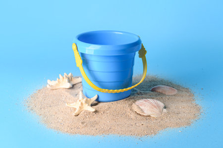 Toy bucket for children with sand on color backgroundの写真素材