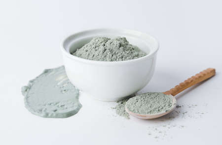 Bowl and spoon with cosmetic clay on white backgroundの写真素材